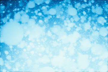 Abstract shimmering bokeh or glitter lights on blue background. Circles and defocused particles. Template for design