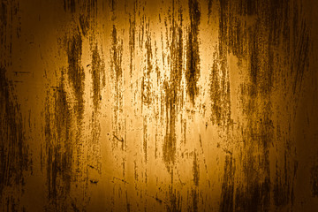 The texture of a golden wall with peeling paint
