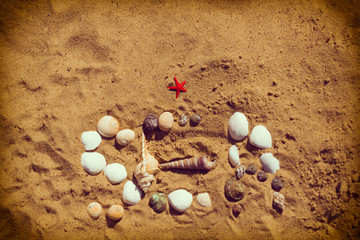Word 'Sea' lined with seashells. Sand