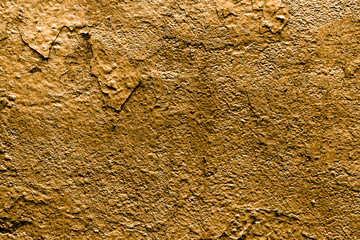 The texture of a golden wall with peeling paint