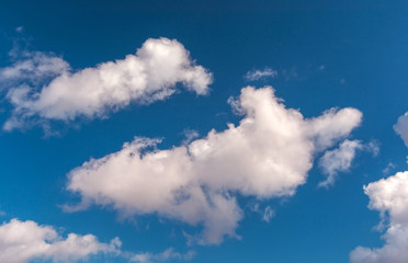 Naklejka na ściany i meble Voluminous clouds on a blue summer sky.