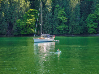 Boater making his way in kayak to his anchored boat