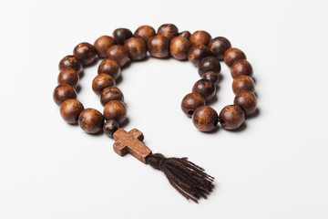 Rosary and a cross on a light gray background. 
