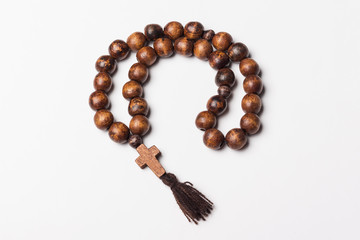 Rosary and a cross on a light gray background. 