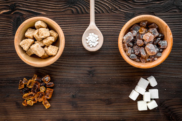 lumps of sugar in bowls on wooden table background top view