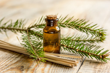 aromatherapy with organic spruce oils in glass bottles on wooden table background