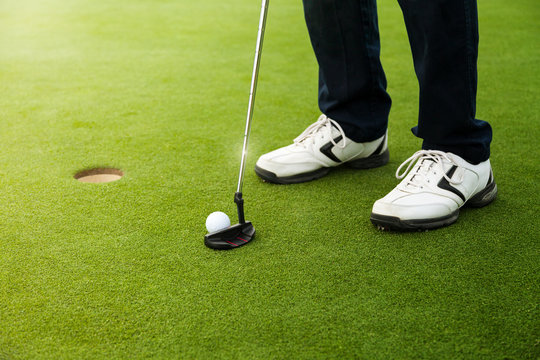 Golfer Preparing For A Putt On The Green.