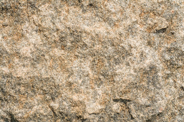 Texture of the surface of an antique stone wall under natural light by sunlight, abstract background