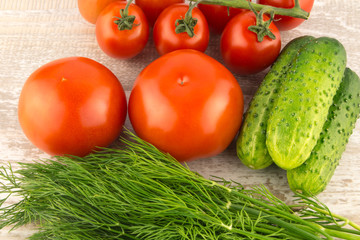 Cucumber, tomato, pepper and fennel on a white wooden background close up.