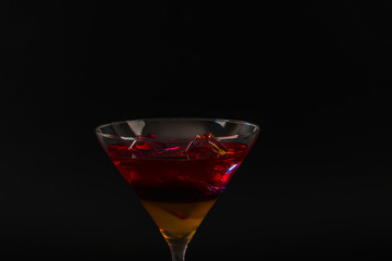 Colorful drink in a cocktail glass, with ice cubes, summer drink