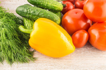 Cucumber, tomato, pepper and fennel on a white wooden background close up.