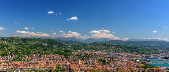 Aerial view of the port an the city of La Spezia with boats and mountains at the horizon.
