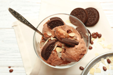 Delicious chocolate ice cream with nut flakes and cookies in glass bowl