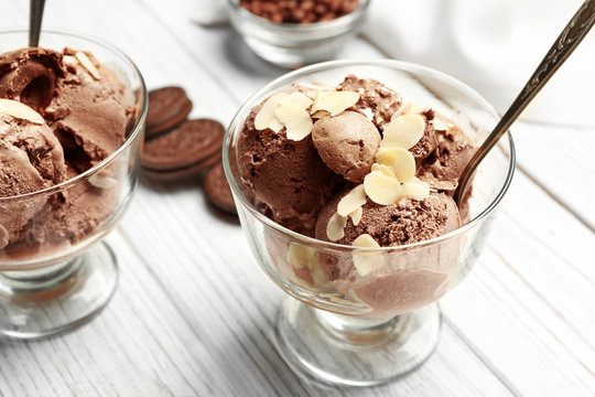 Delicious chocolate ice cream in glass bowl on wooden table