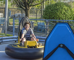 Boy laughing and determined while driving bumper cars