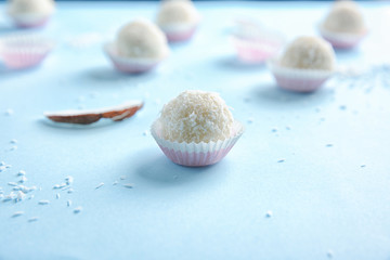 Tasty candies in coconut flakes on table