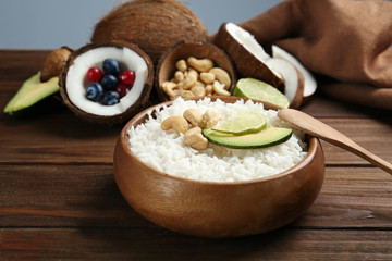 Coconut rice with cashew nuts, avocado and lime slices on wooden table