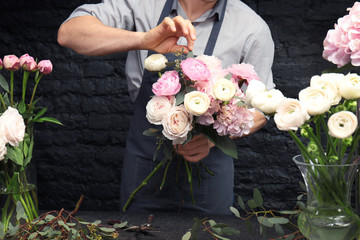 Mannelijke bloemist die een mooi boeket maakt in de bloemenwinkel, close-up