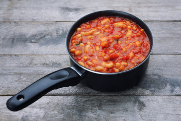 Stew pan with Italian butter beans on wooden background