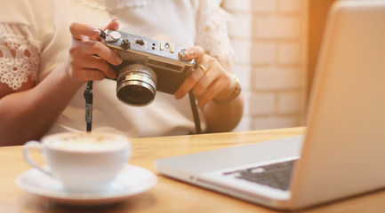 happy woman check photos on camera while sitting on sofa