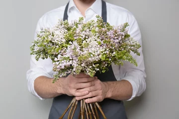 Photo sur Plexiglas Fleuriste Young florist with beautiful bouquet on grey background