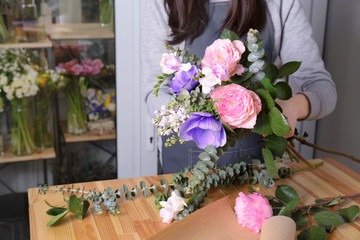 Female florist creating beautiful bouquet in flower shop