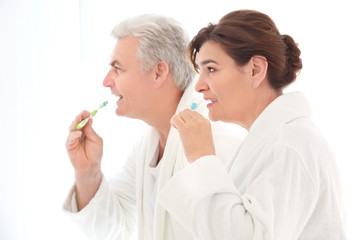 Senior couple cleaning teeth at home