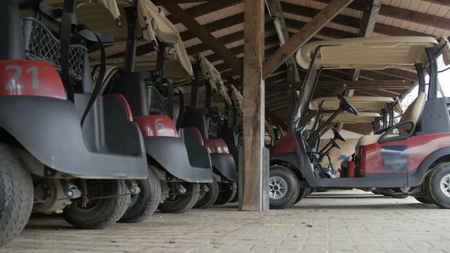 Golf carts parked In the covered wooden place