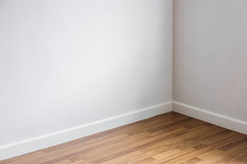 Laminated wood floor with white wall, room's corner
