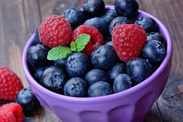 Assorted berries in a ceramic bowl on table