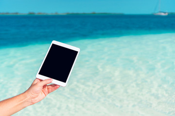 Close up laptop on the background of turquoise ocean at tropical beach