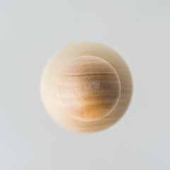 Surreal design concept - real wooden ball float on grey background like the planet on the universe