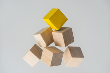 Business concept - Abstract geometric real floating wooden cubes layout like triangle on grey...