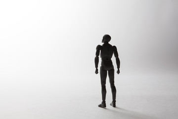 Male figurine silhouette standing in powerful pose looking up on white background with copy space. Conceptual image conveying concept of dreams, leadership and aspirations