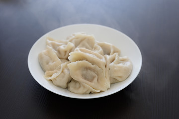 A plate of cooked Chinese dumplings isolated on black background. A must eat for Chinese New Year.