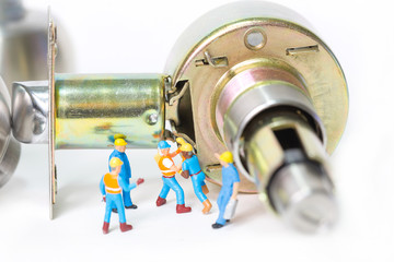 Selective focus of miniature engineer and worker prepare Stainless steel round ball door knob component on white background as Locksmith, business and industrial concept.