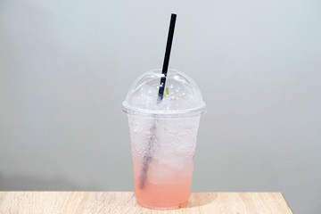 Closeup of Rose Italian Soda with lychee and lemon on wooden table, Summer Cocktail or Tropical Mocktail.