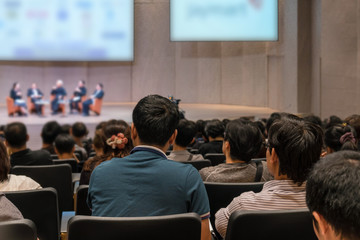 Fototapeta premium Rear view of Audience over the speakers on the stage in the conference hall or seminar meeting, business and education concept