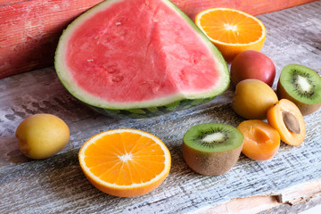 Kivi, orange, peach, watermelon on the wood background