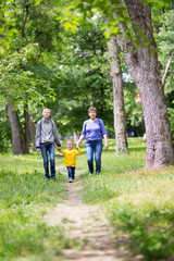 Grandmother is walking with her grandchildren