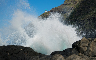 View from of a Crashing Wave with a Lighthouse in the Background