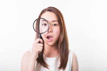 Young woman looking through a magnifying glass on a white background