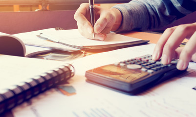 Young woman writing make note and doing calculate finance at home office.