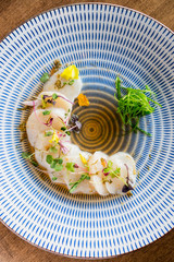 Raw scallops top view. Fresh raw scallops sashimi dish. Sashimi is a Japanese cuisine delicacy consisting of sliced raw meat (usually fish and seafood) often served in sushi restaurants.