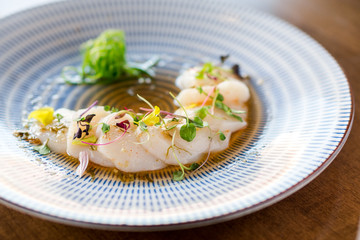 Raw scallops sashimi seafood dish. Fresh raw scallops sashimi dish. Sashimi is a Japanese cuisine delicacy consisting of sliced raw meat (usually fish and seafood) often served in sushi restaurants.