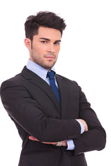 serious young businessman standing with hands crossed