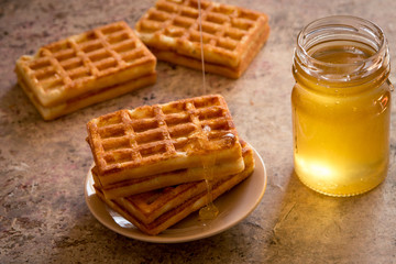 Baked waffles and organic sweet honey for breakfast