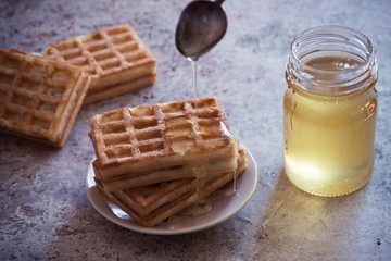 Baked waffles and organic sweet honey for breakfast