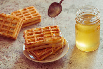 Baked waffles and organic sweet honey for breakfast