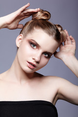 Fototapeta premium Young teen female beauty portrait with day makeup and bun hair style